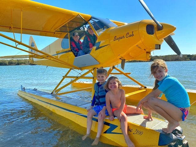 Tree kids ask Ken Wittekiend and Tim Casey to look at the Super Cub. 