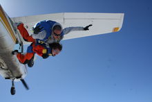 2 people jumping out of a Cessna 182