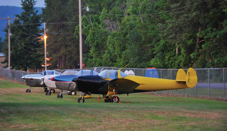 Ercoupes tied down on a grassy ramp