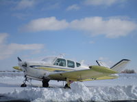 A Beechcraft Bonanza sits in the snow.