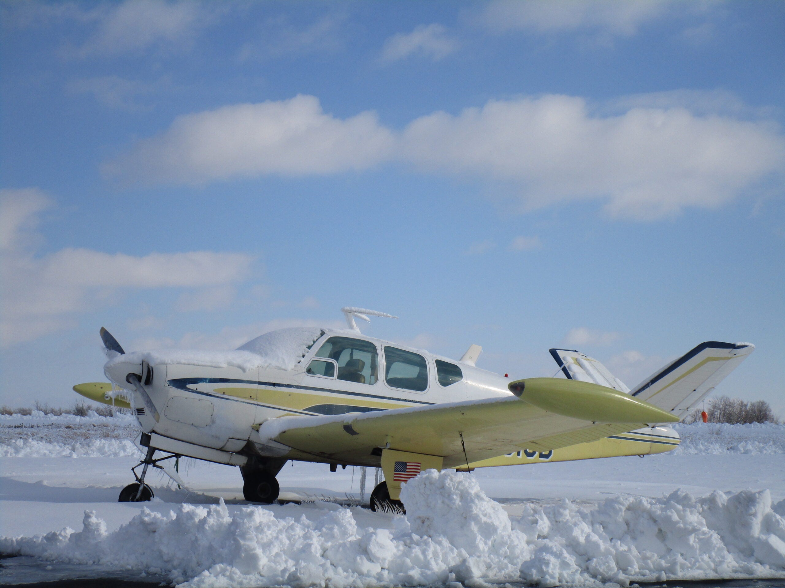 A Beechcraft Bonanza sits in the snow.